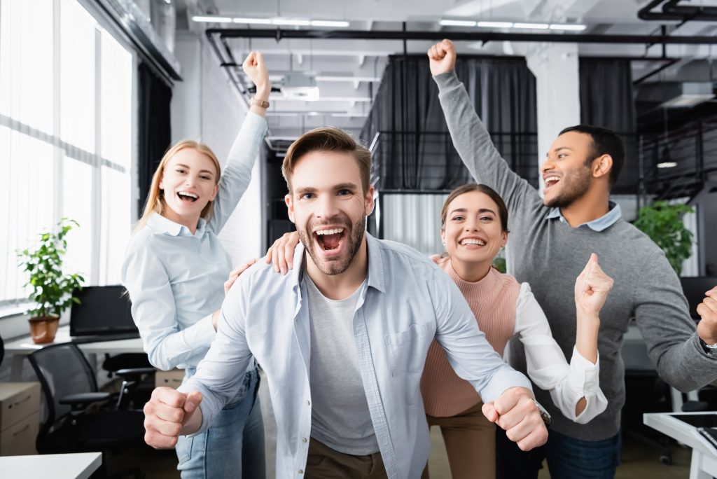 Cheerful multiethnic businesspeople showing yes gesture in office