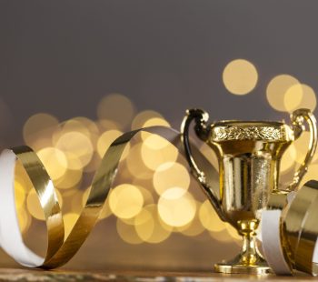 Gold award trophy against bright blurred lights